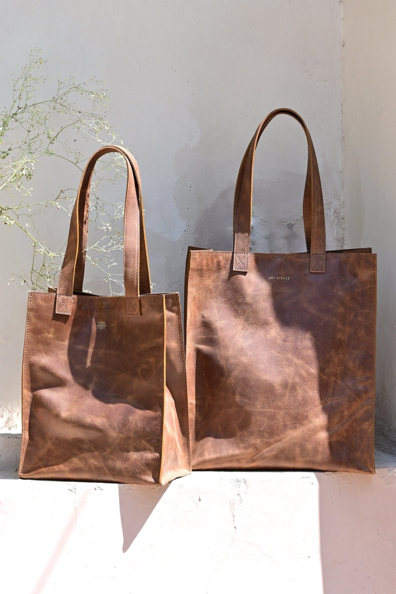 Freebie medium leather tote bag flat lay — Art Avenue