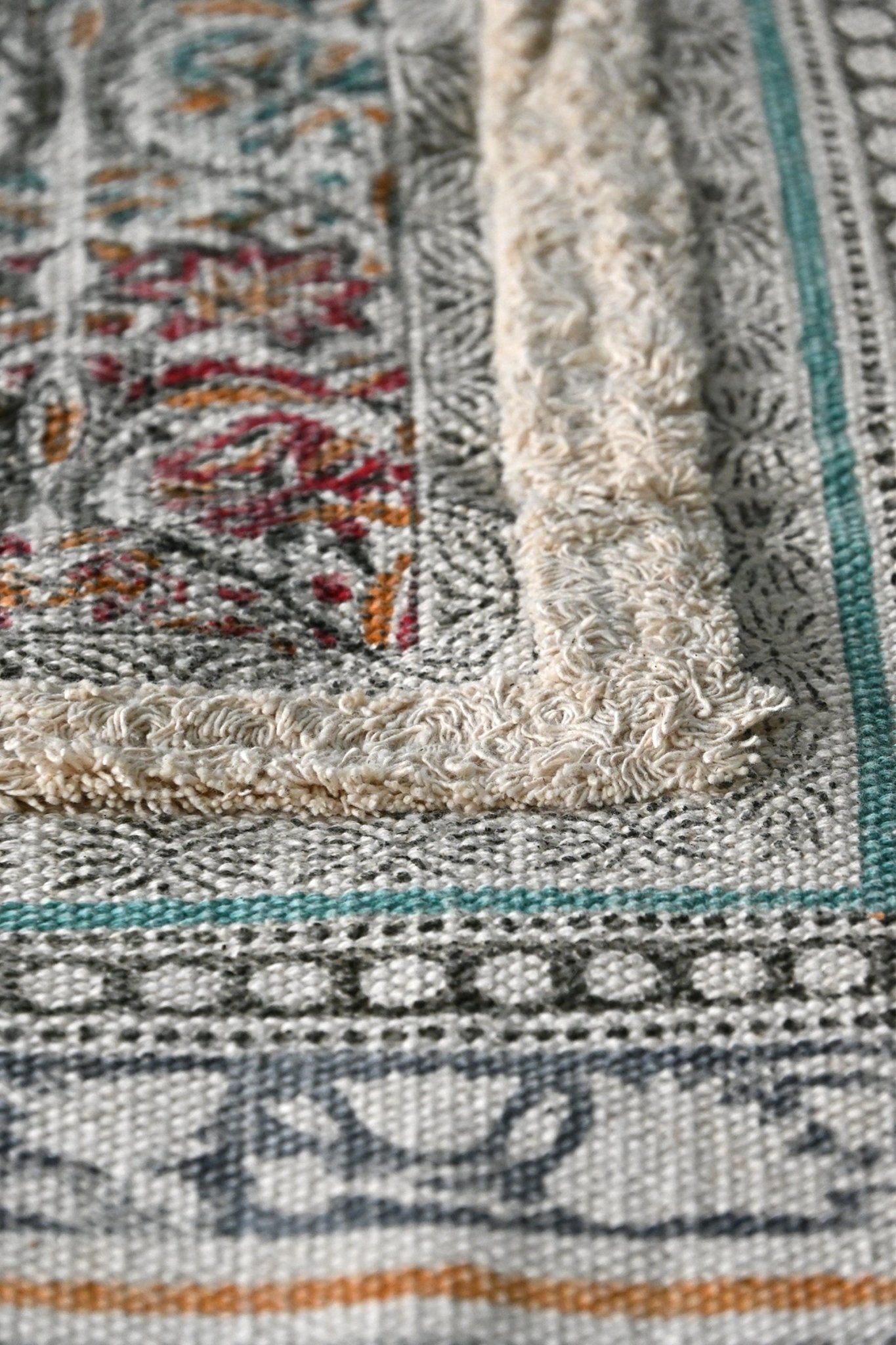 Detail of block-print on green tasselled dhurrie rug — Art Avenue